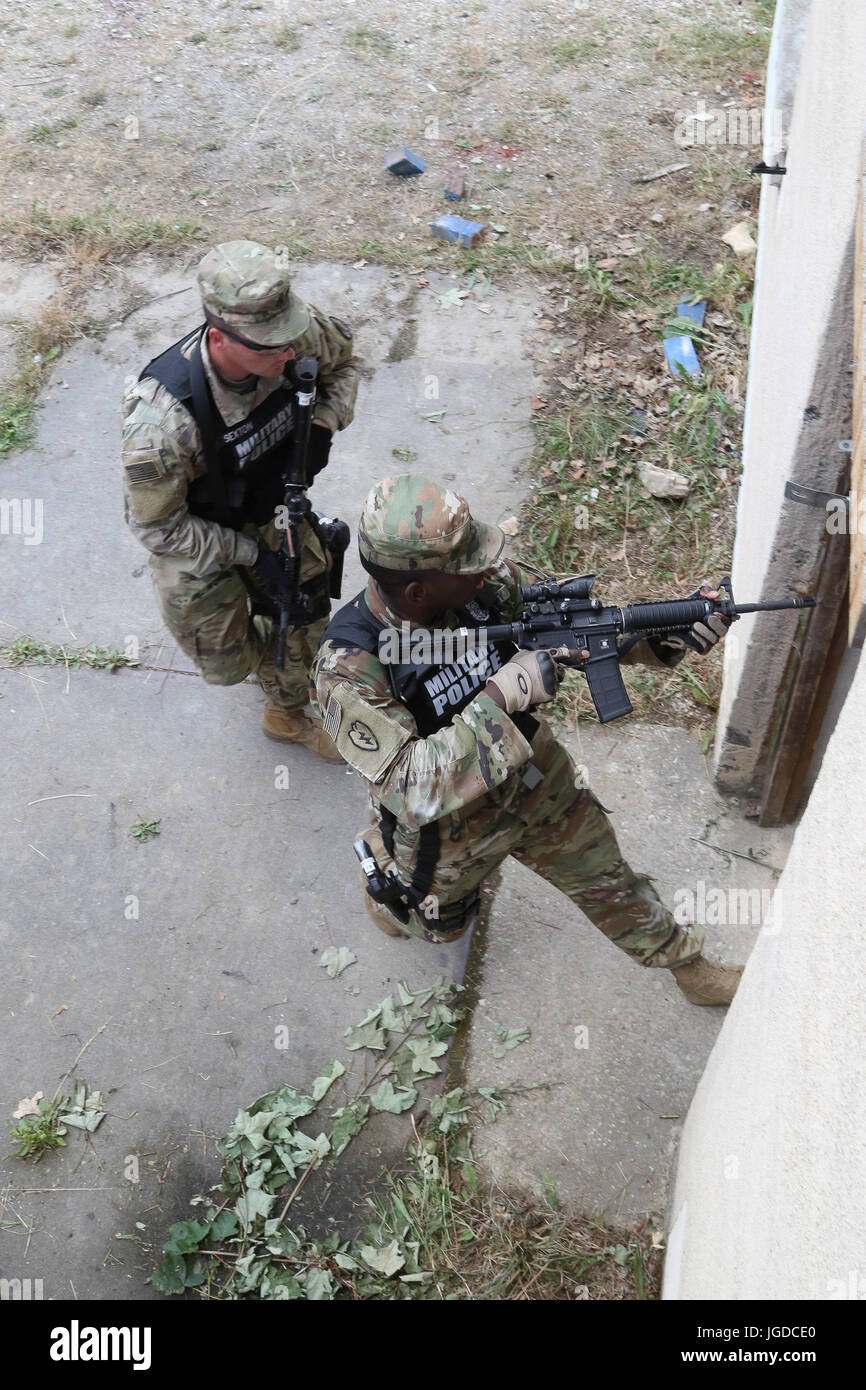 La police militaire entrer dans un bâtiment qui a été reprise par une personne hostile avec une arme à feu au cours d'un scénario de formation de tir le 28 juin 2017 à JMRC en Hohenfels, Allemagne. La 591e compagnie MP, 93e Bataillon, MP MP 89e Brigade à Fort Bliss, au Texas est la formation en préparation de leur KFOR MNBG-e mission de sécurité. (U.S. Photo de l'armée par le sergent. Nicolas Farina) Banque D'Images