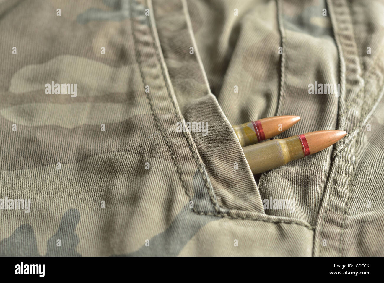 Deux balles de fusil camo militaire caché dans le pantalon poche de munitions militaires. Banque D'Images