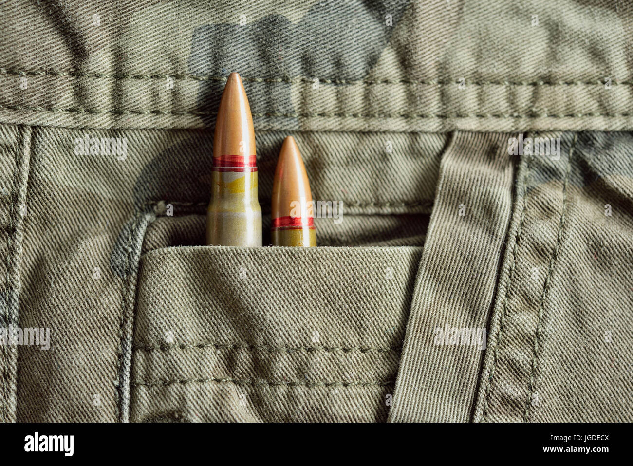 Deux balles de fusil camo militaire caché dans le pantalon poche de munitions militaires. Banque D'Images