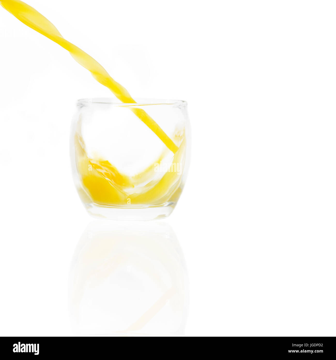 Verser le jus d'isolés dans un verre sur un fond blanc orange en couleur angle de liquide peut être ajouté à n'importe quel objet ou centrifugeuse Banque D'Images