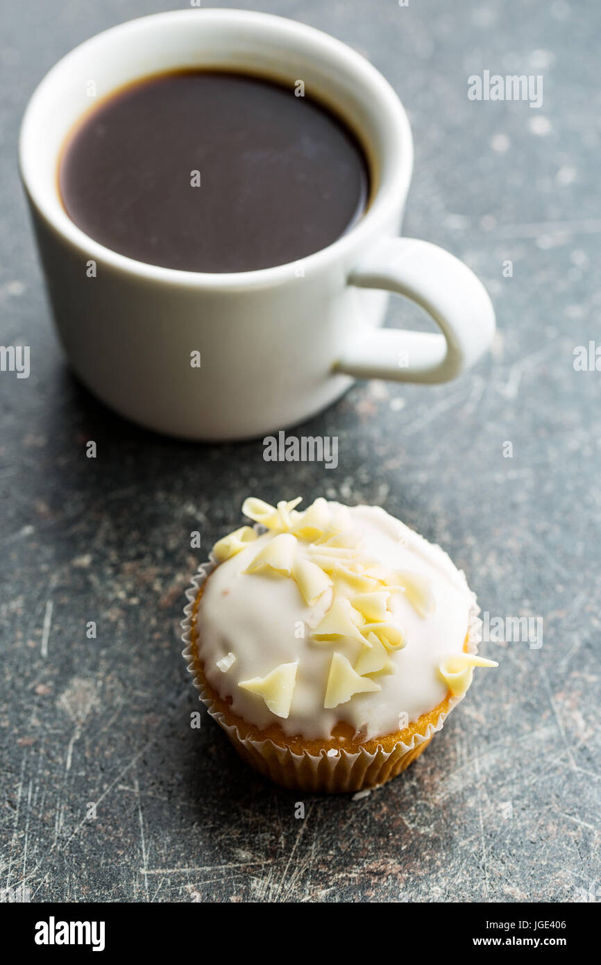 Tasse à café et petits gâteaux savoureux sur la table de cuisine. Banque D'Images