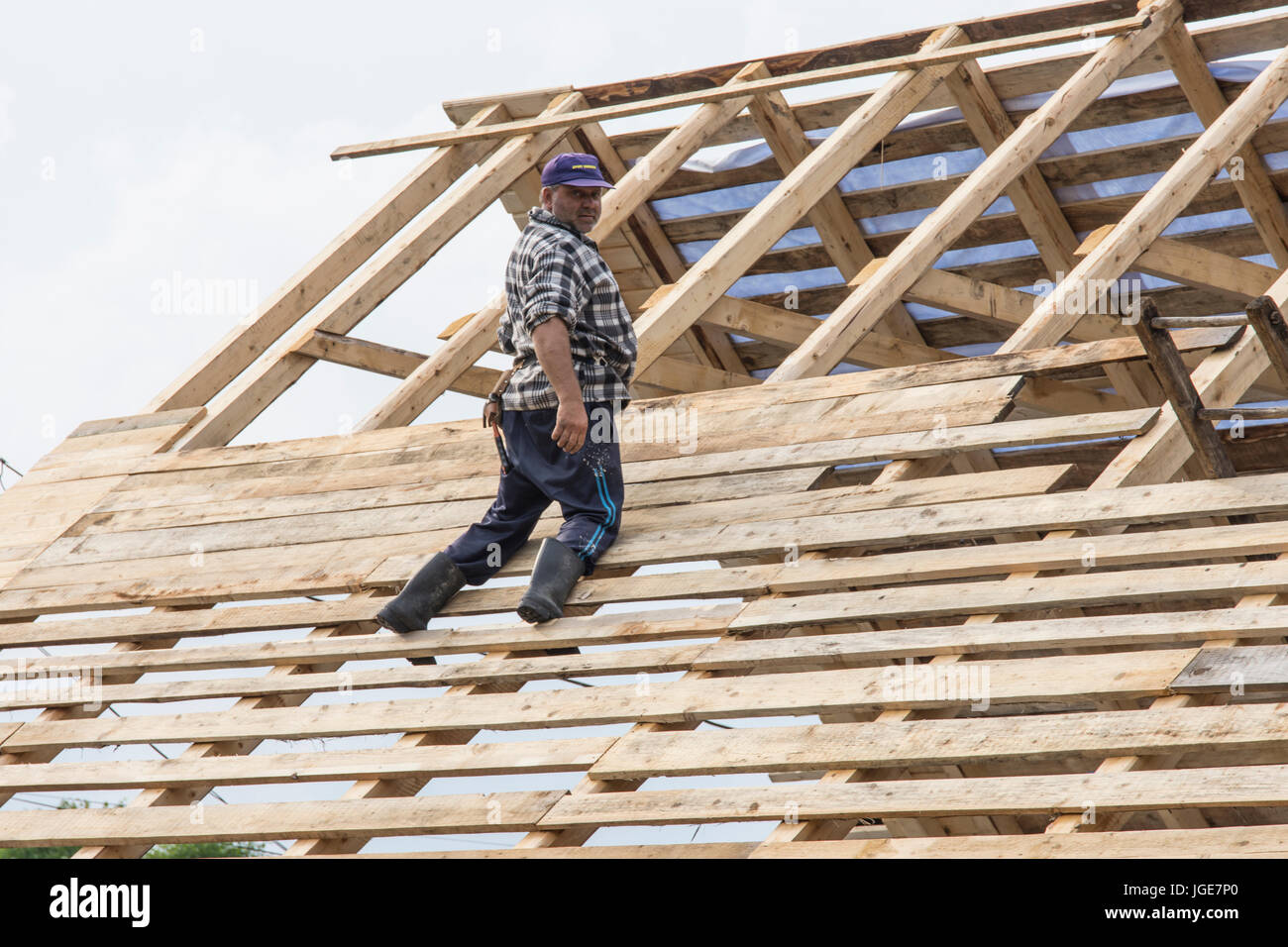 Un homme travaille sur la construction d'un pavillon en bois dans la région de Maramures, Roumanie Banque D'Images