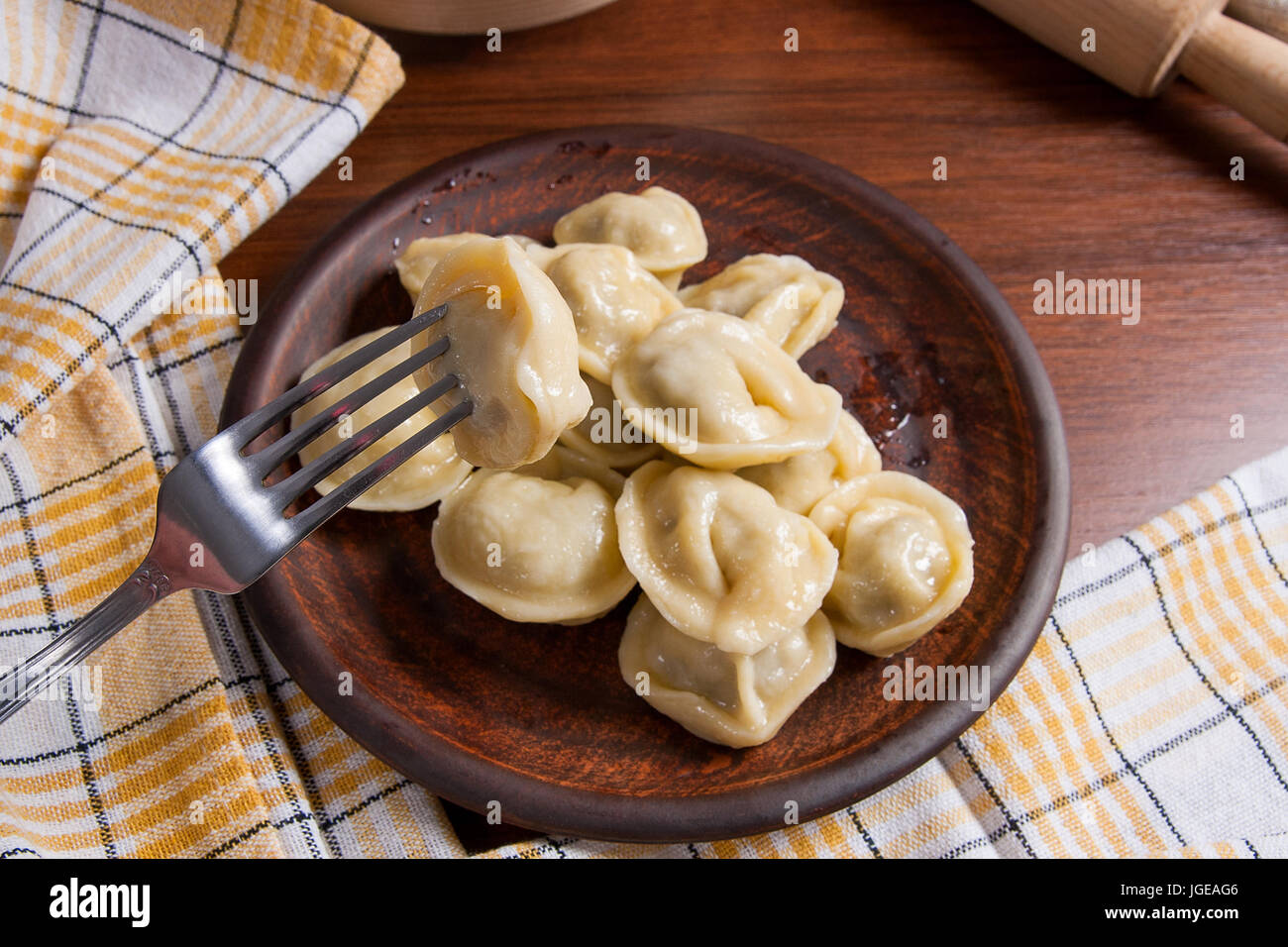 Vue rapprochée de la viande bouillie des dumpling sur fourchette métallique et servi dans la plaque d'argile quenelles avec sauce crémeuse et fourchette métallique. La composition à rusti Banque D'Images