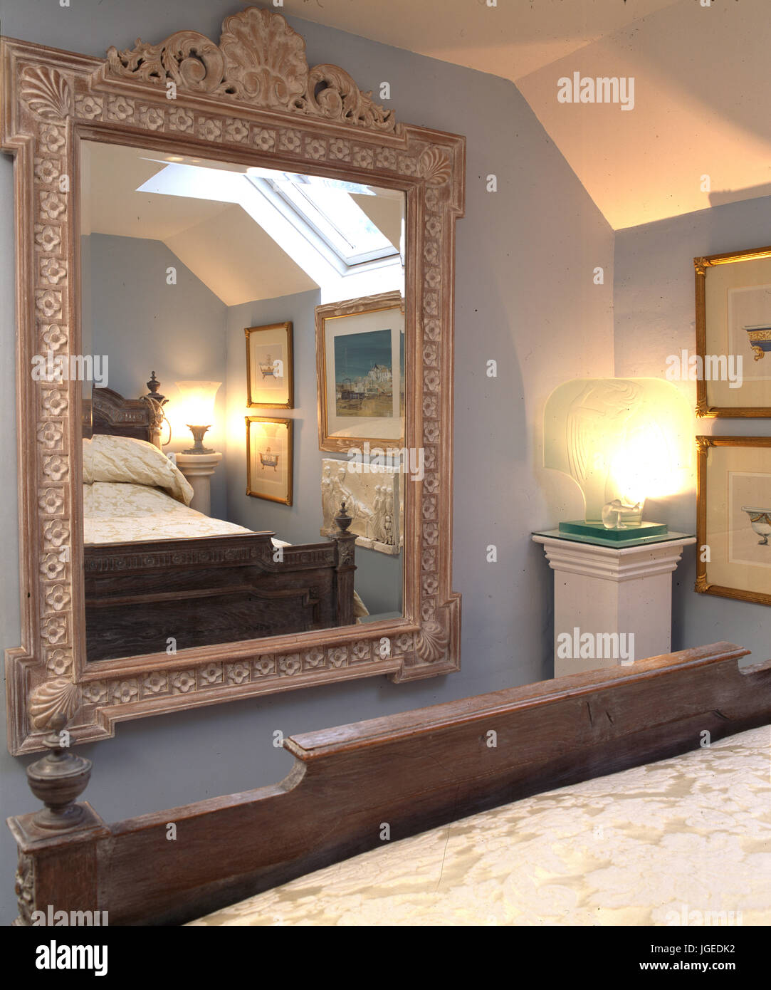 Grand miroir en pied de lit dans une chambre mansardée Banque D'Images