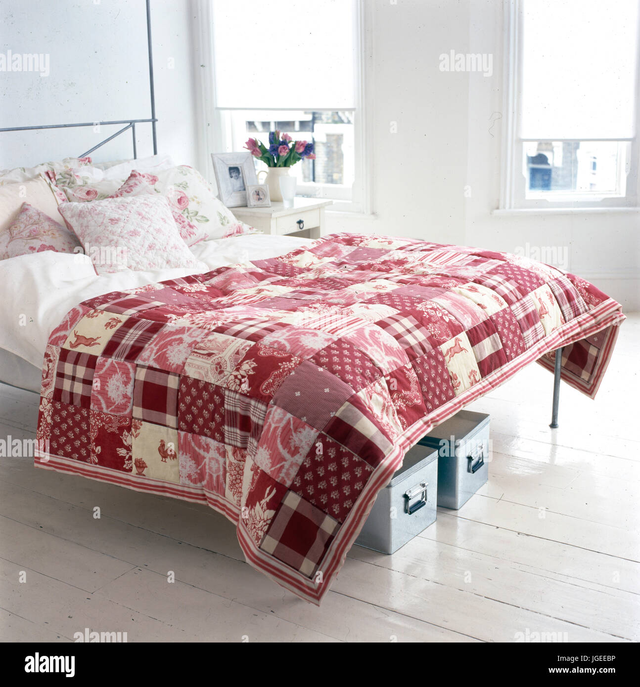 Chambre à coucher moderne avec courtepointe rose sur lit de métal avec sous  lit boxesd de stockage Photo Stock - Alamy