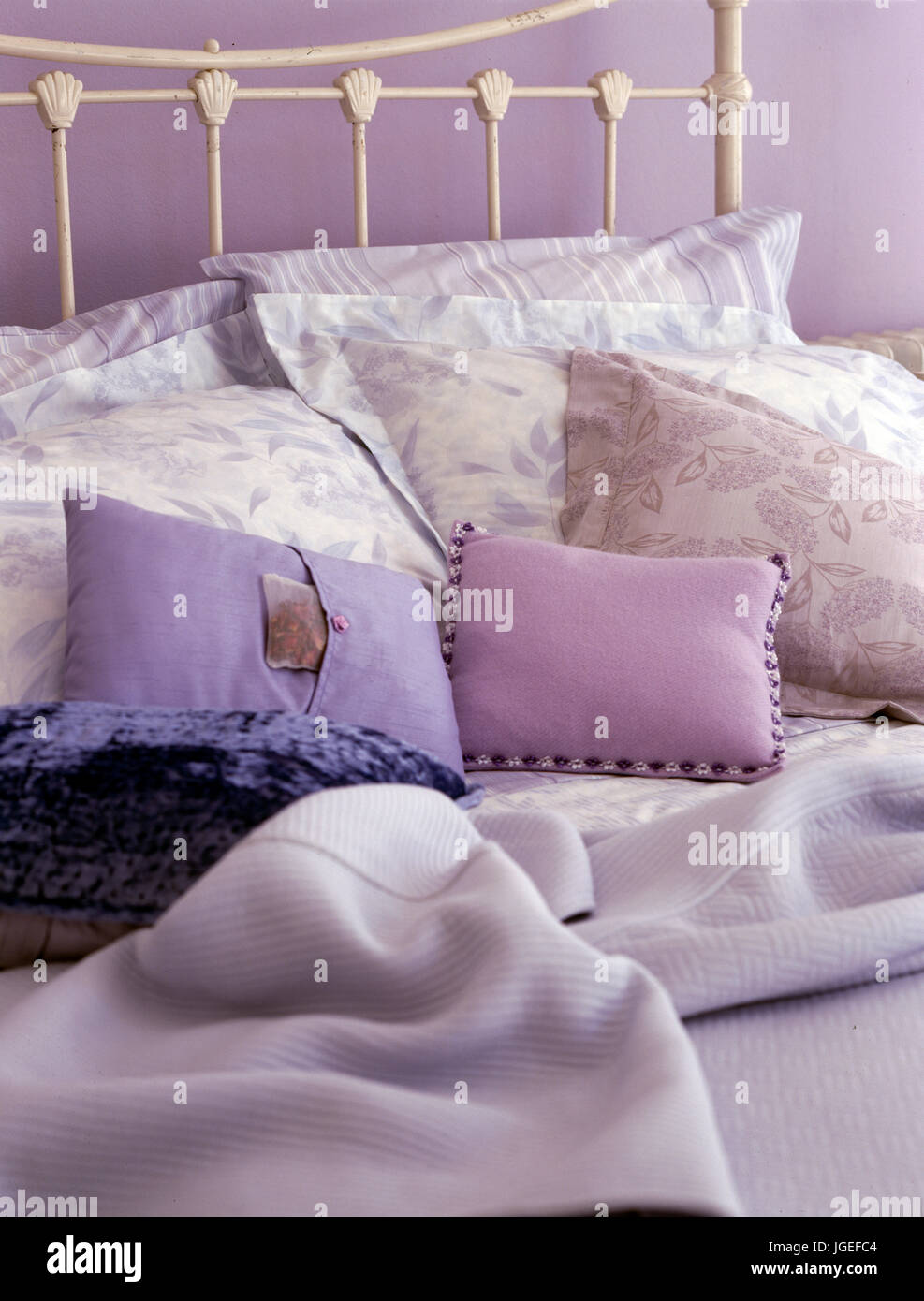 Close-up de coussins et de draps à motifs floraux sur lit de métal blanc Banque D'Images