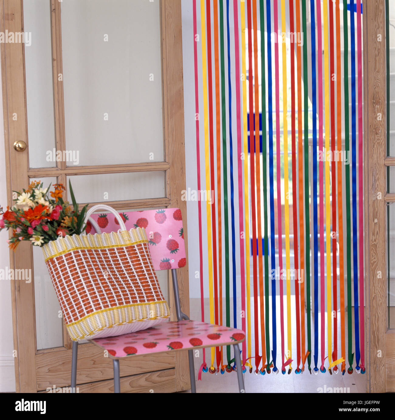 Panier sur plastique moderne chaise devant le rideau de perles et ruban  Photo Stock - Alamy