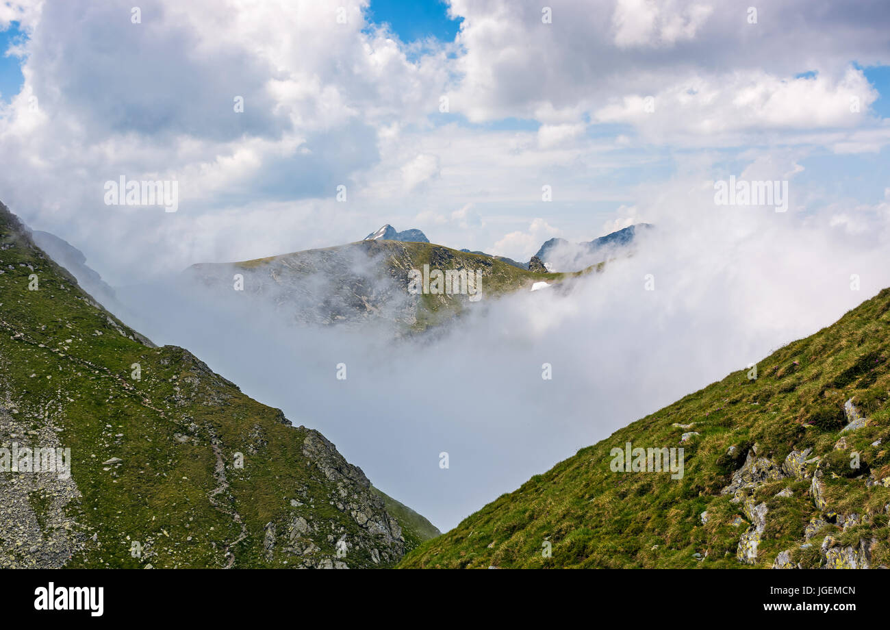 Pic de haute montagne dans les nuages entre les collines. Majestic météo à Carpates Banque D'Images