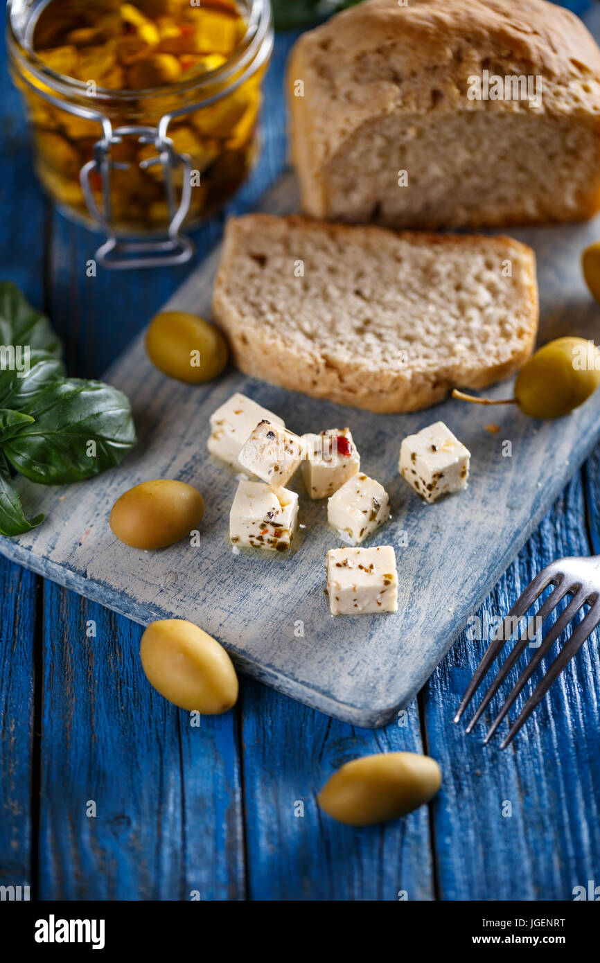 Cubes de fromage feta aux olives sur fond de bois bleu Banque D'Images