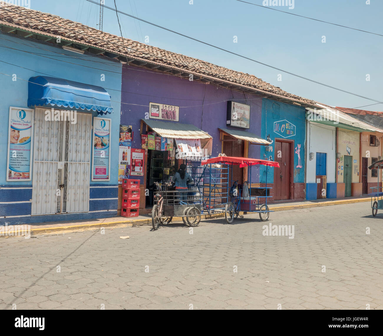 Taxi stationné à l'extérieur de la pédale d'un petit magasin vendant Coca Cola en vieux bâtiments coloniaux à Corinto, Nicaragua Banque D'Images