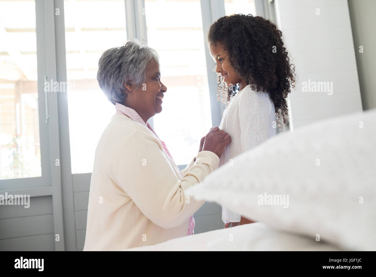 Grand-mère s'habillant avec sa petite-fille dans la chambre à la maison Banque D'Images