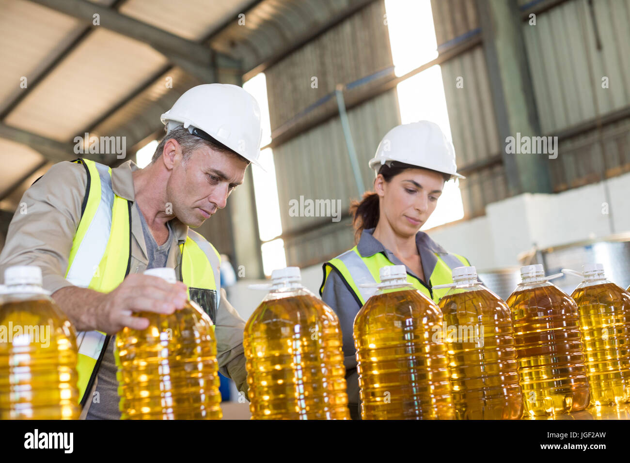 La vérification de dossiers de travailleurs en usine de bouteilles d'huile Banque D'Images