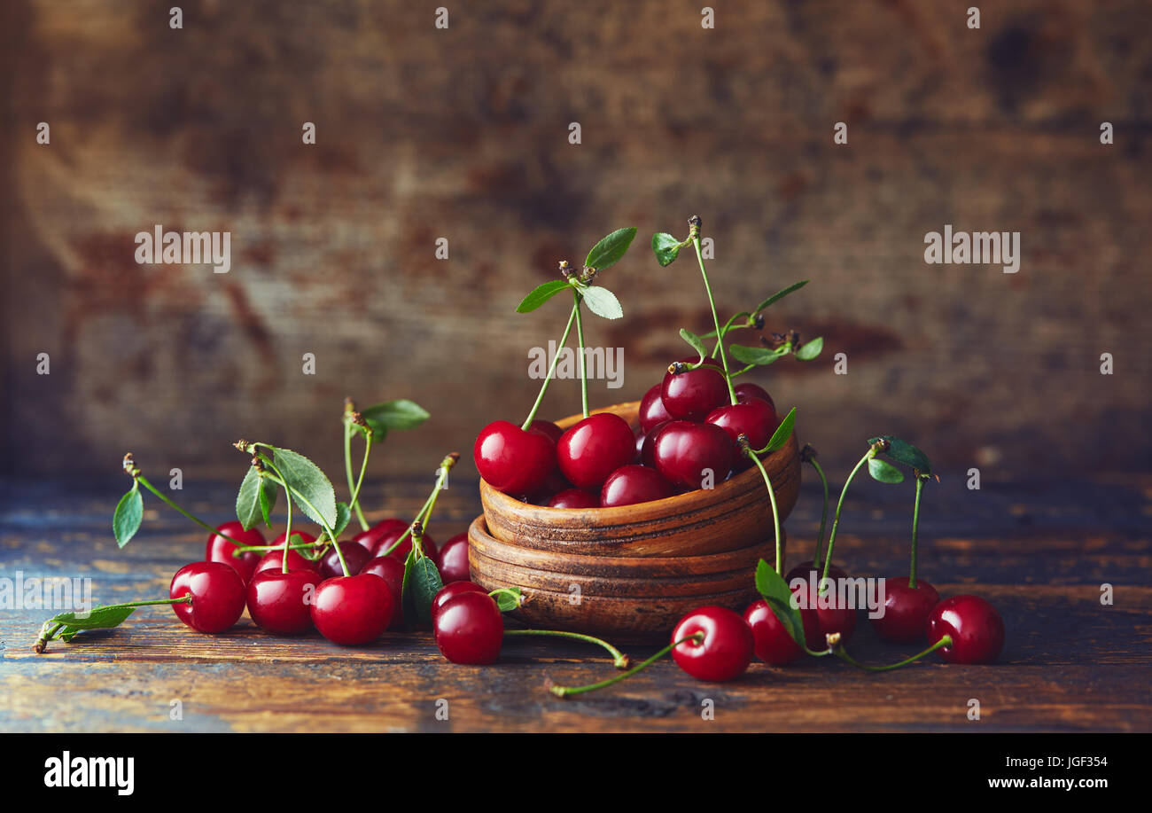 Les cerises dans un bol sur une table en bois. Cerises fraîchement récoltées dans un bol sur une table en bois. Banque D'Images