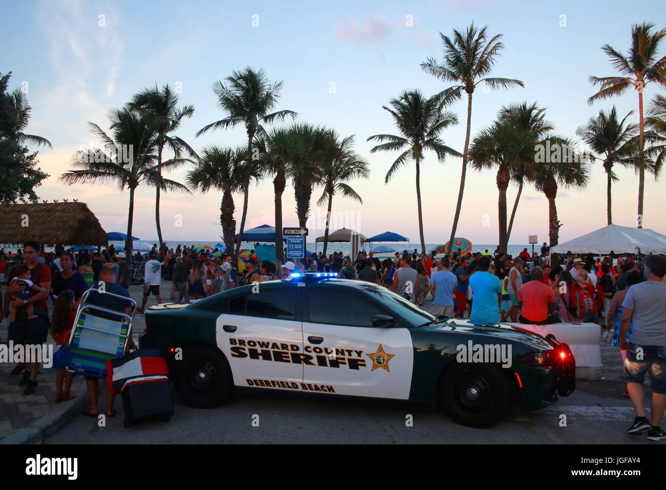 Le comté de Broward Sheriff Voiture de police Lights clignotant à Deerfield Beach, en Floride, après le coucher du soleil en face de barricades et foule de personnes, le 4 juillet 2017 Banque D'Images