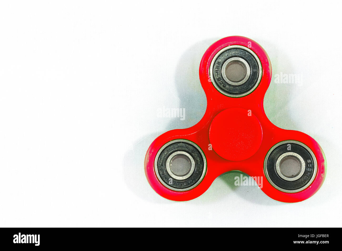 Fidget Spinner blanc fond isolé dans. La fidget spinner est un jouet, une petite broche, le corps en rotation pivote sur un roulement à billes qui lui permet Banque D'Images