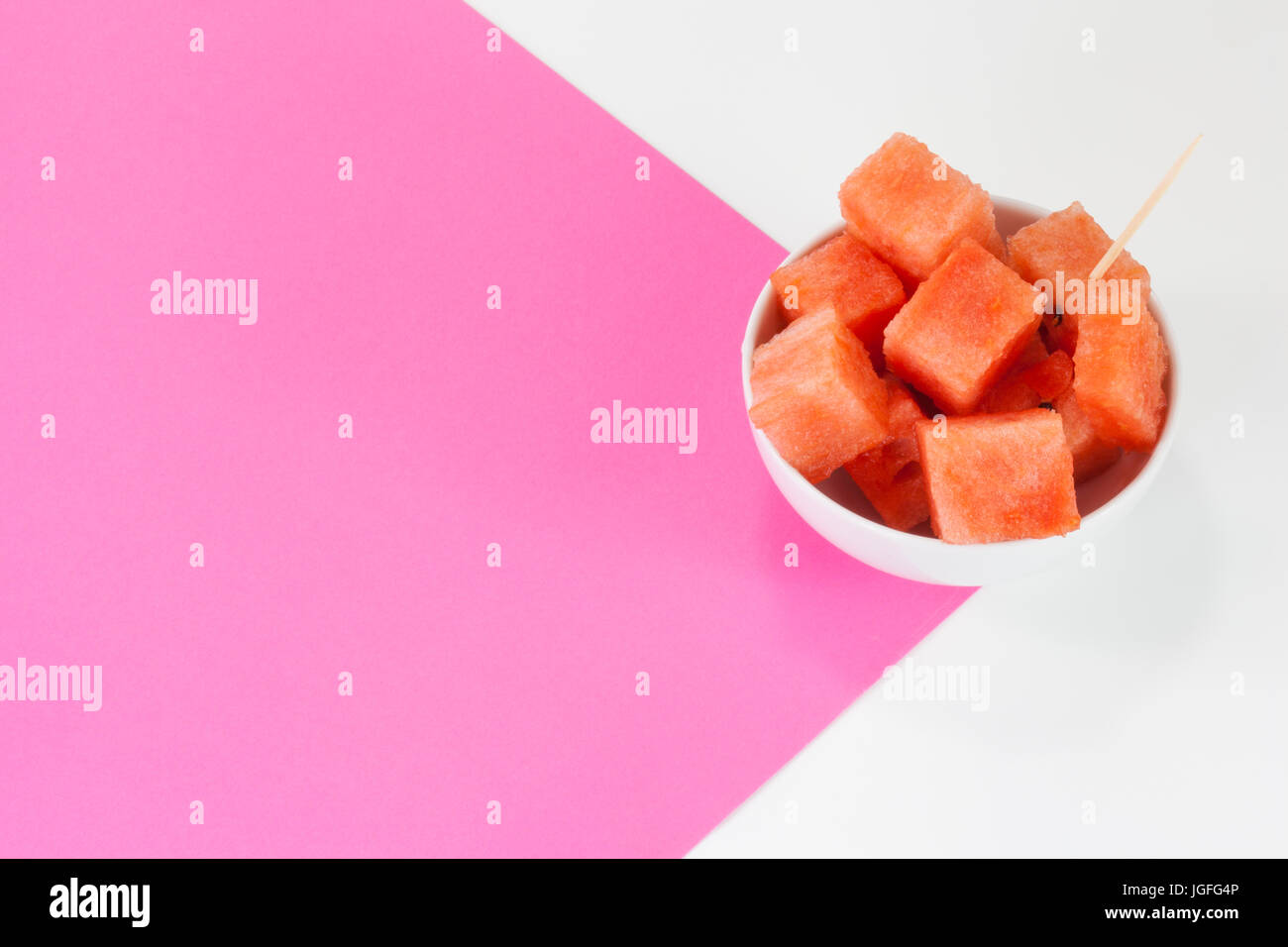 Watermelon chuncks dans un bol blanc, fond bicolore. Banque D'Images