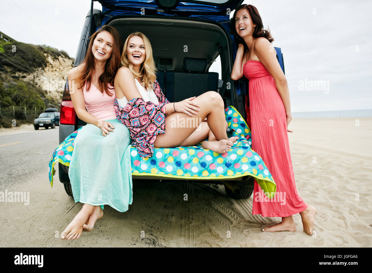 Laughing Caucasian women à l'éclosion de voiture sur beach Banque D'Images