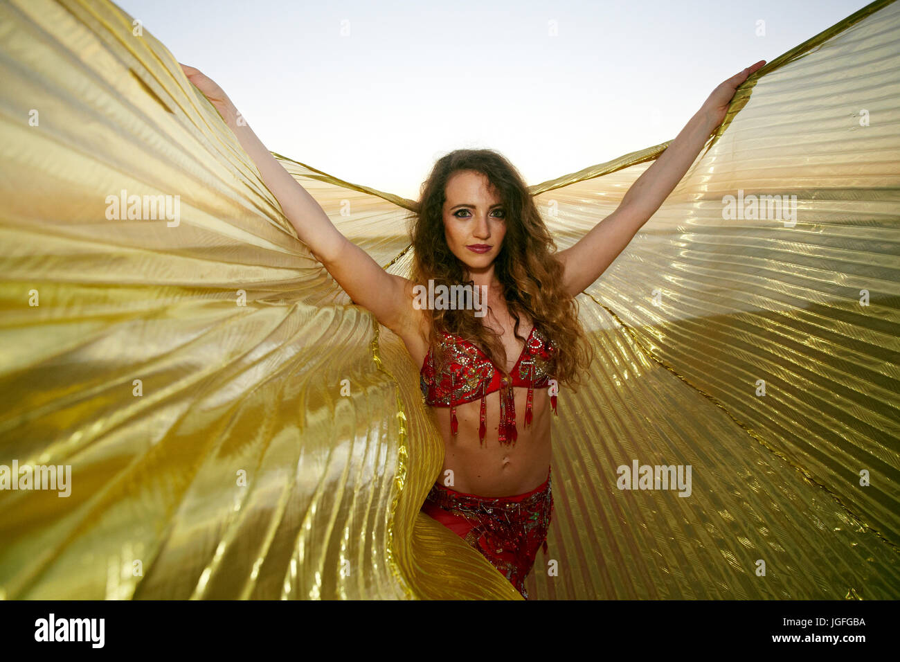 Woman holding belly dancer cape on beach Banque D'Images