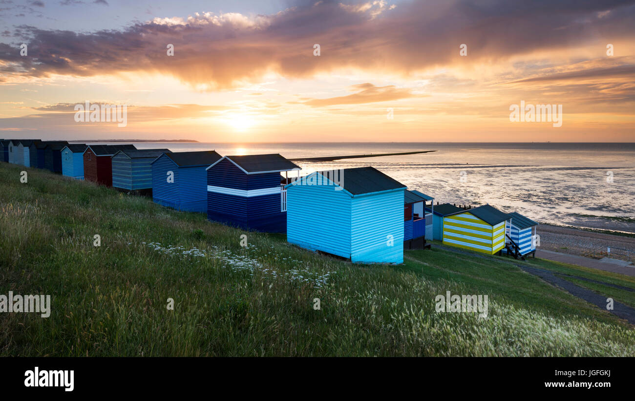 Whitstable cabanes de plage sur les pentes de Tankerton au coucher du soleil. Banque D'Images