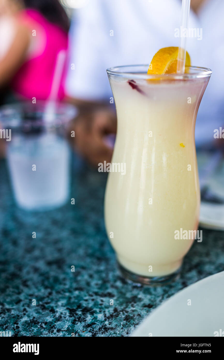Gros plan macro de pina colada avec du citron dans le verre avec de la paille sur la table Banque D'Images