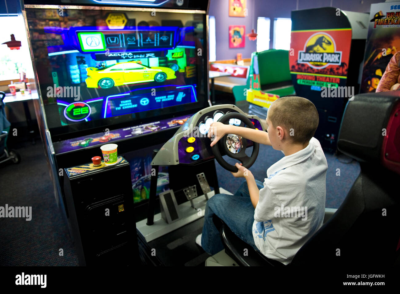 Garçon jouant un jeu vidéo d'arcade. Banque D'Images