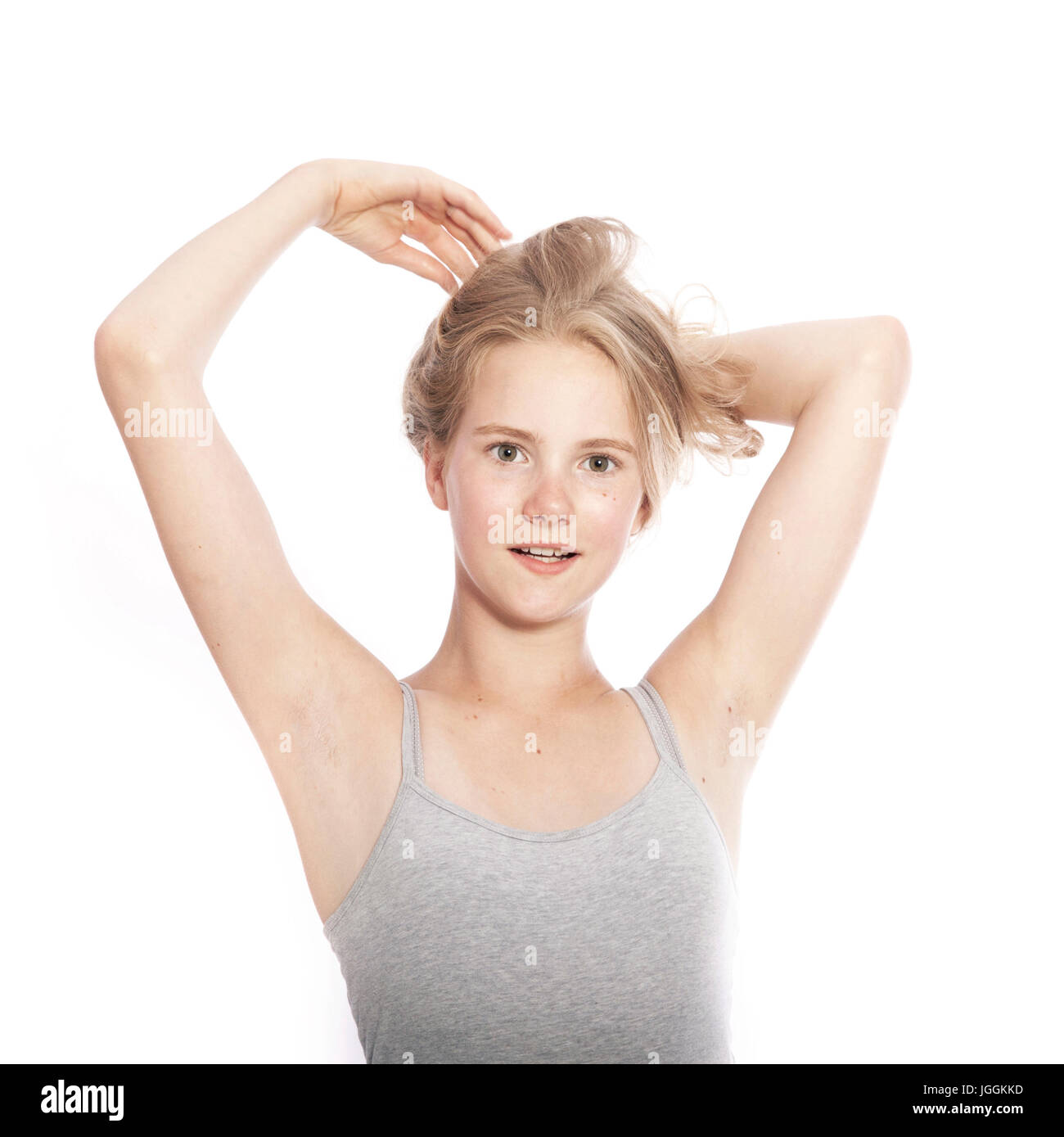 Young teen girl détient des cheveux blonds à fond studio blanc Banque D'Images