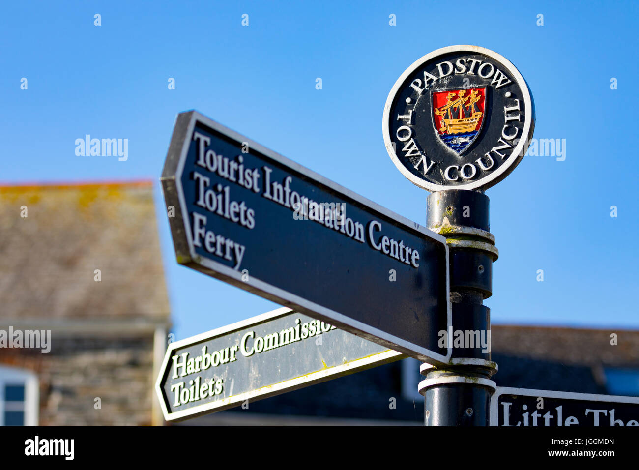 Un conseil de la ville de Padstow tourisme fonte informations inscription avec le crest pointant dans des directions différentes, contre un ciel d'été bleu clair, Padstow, Angleterre Banque D'Images