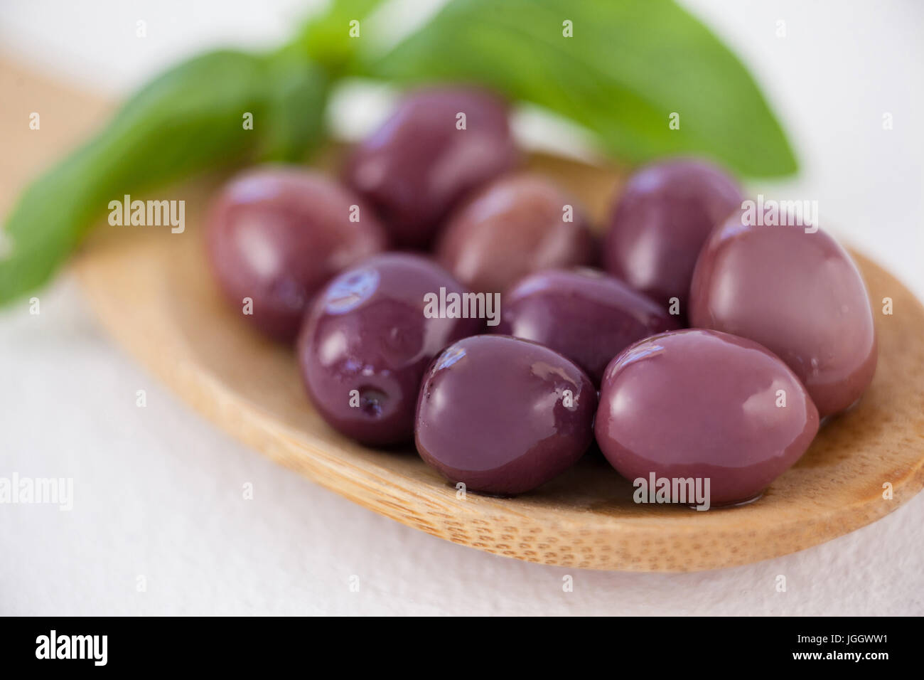 Close up of brown olives en cuillère en bois sur la table Banque D'Images