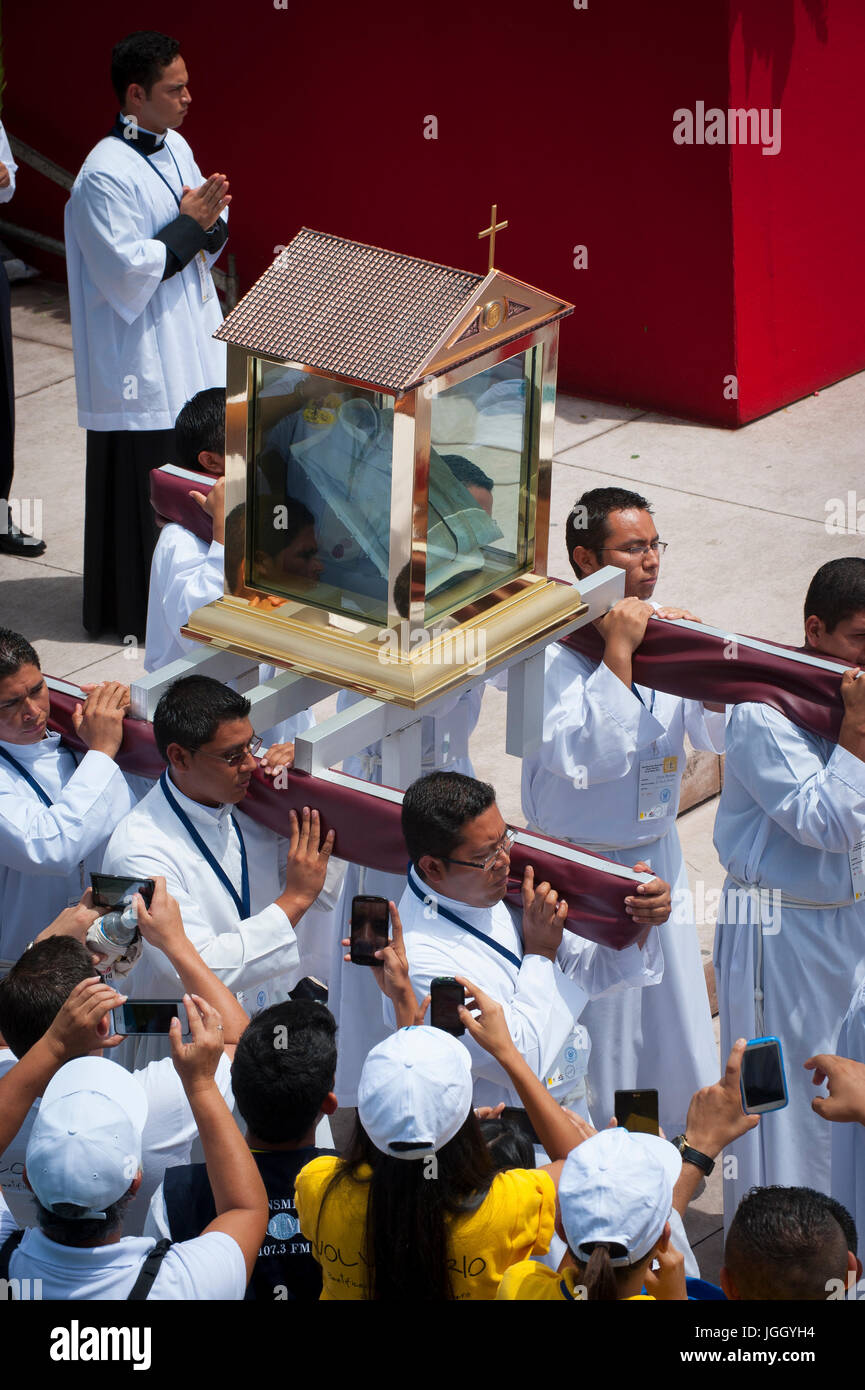 Les prêtres catholique salvadorienne porter une relique - La chemise tachée de sang - de l'archevêque Oscar Romero martyrisés. L'archevêque a été immolé sur l'autel de son église de la Divine Providence par un homme armé de l'aile droite en 1980. Oscar Arnulfo Romero y Galdamez est devenu le quatrième Archevêque de San Salvador, en remplacement de Luis Chavez, et s'est prononcé contre la pauvreté, l'injustice sociale, d'assassinats et de torture. Romero a été assassiné tout en offrant la messe le 24 mars 1980. Banque D'Images