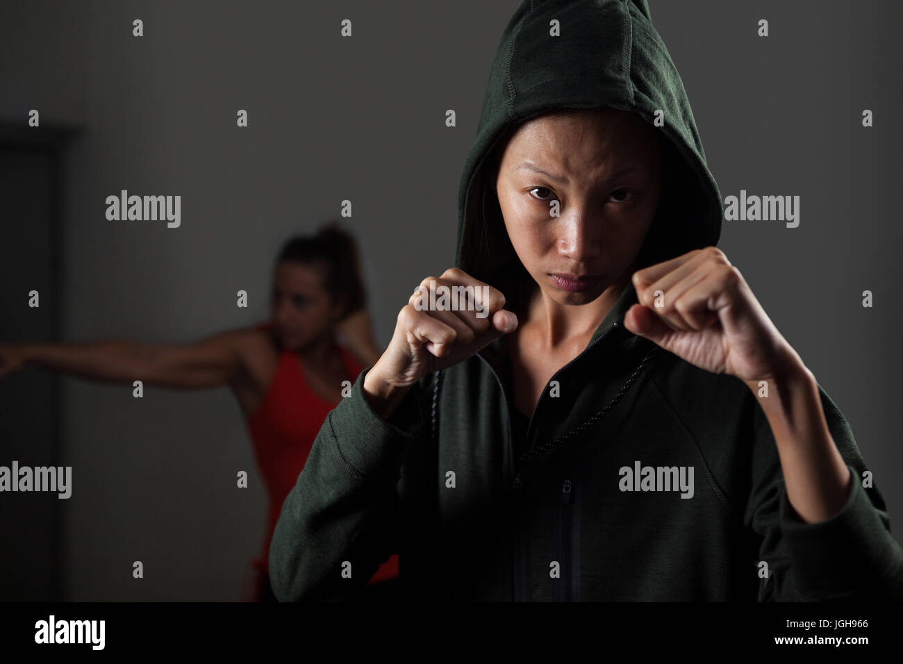 Femmes déterminées dans la pratique de la boxe fitness studio Banque D'Images