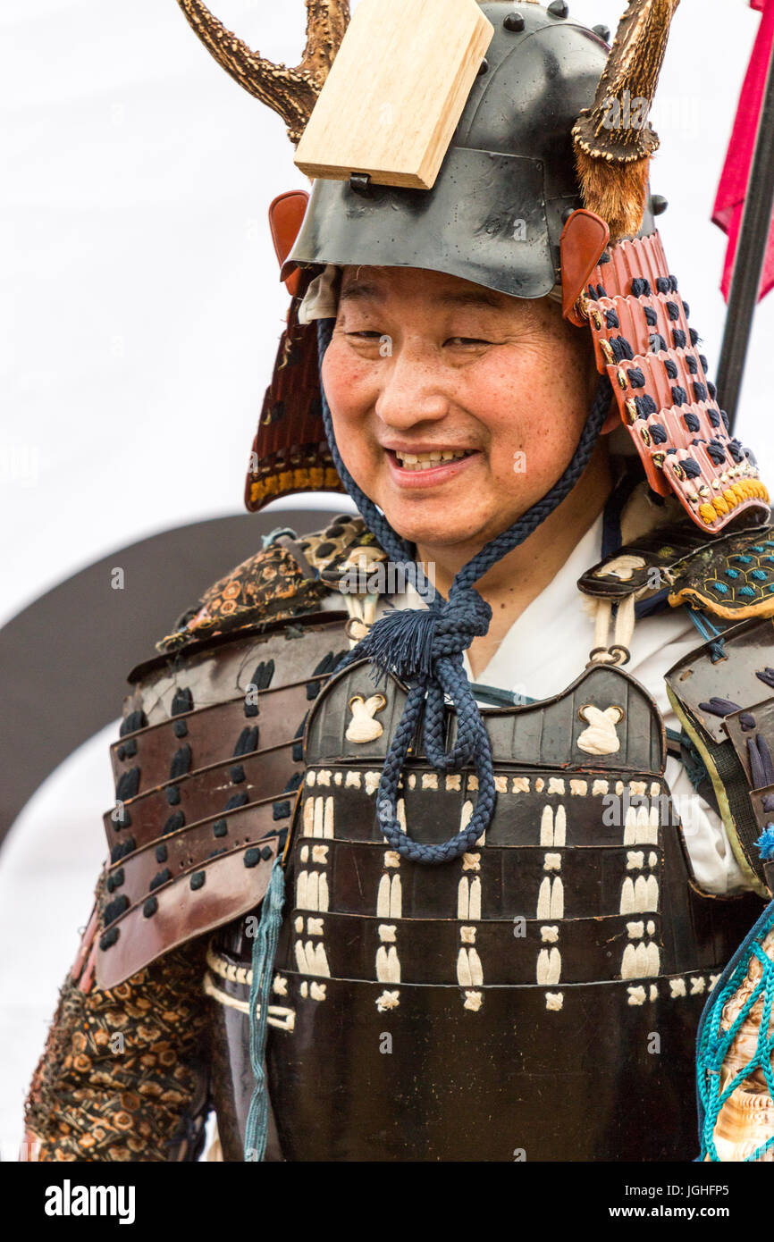 Le Japon, Tatsuno. Festival d'avril. Close up, tête et épaule, smiling man habillé en guerrier Samouraï debout contre fond blanc qui pose pour photo Banque D'Images