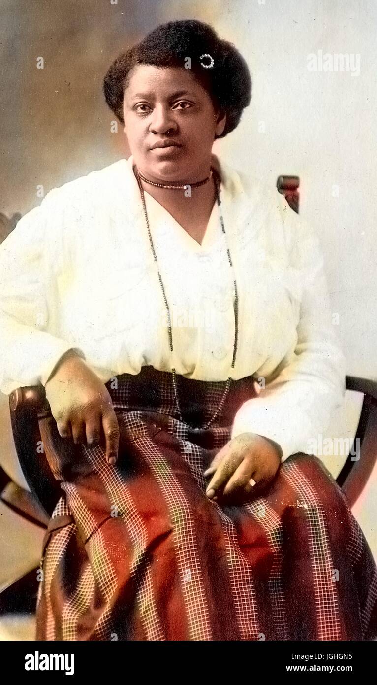 Trois quarts portrait assis, les femmes afro-américaines, portant des modèles de Jupe, chemisier léger, des colliers et des virages en épingle, expression neutre, 1920. Remarque : l'image a été colorisée numériquement à l'aide d'un processus moderne. Les couleurs peuvent ne pas être exacts à l'autre. Banque D'Images