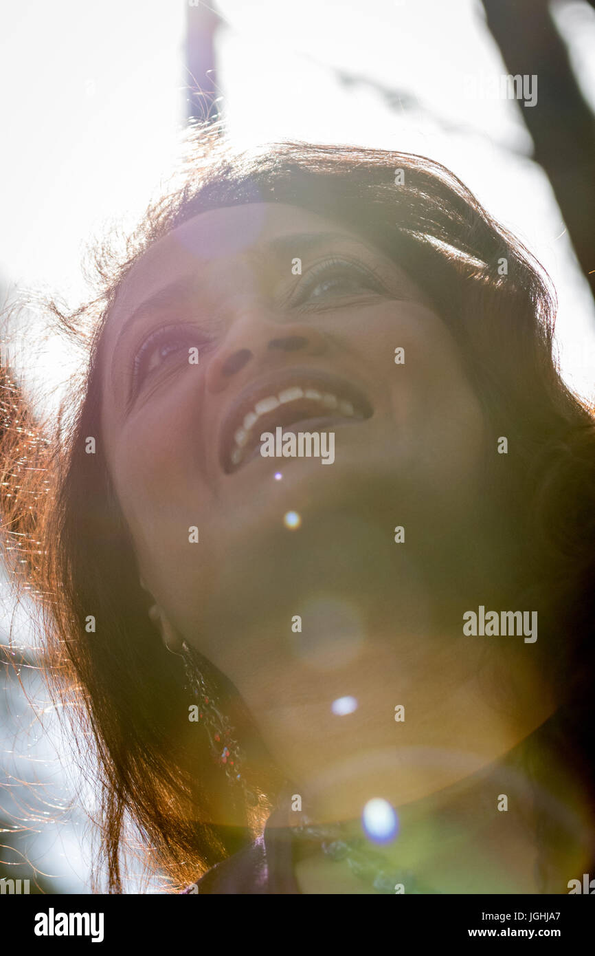 Middle aged smiling woman with smile shot par en dessous avec des reflets. Grand sourire parfait montre les dents et quartier animé de regarder dans les yeux. Banque D'Images