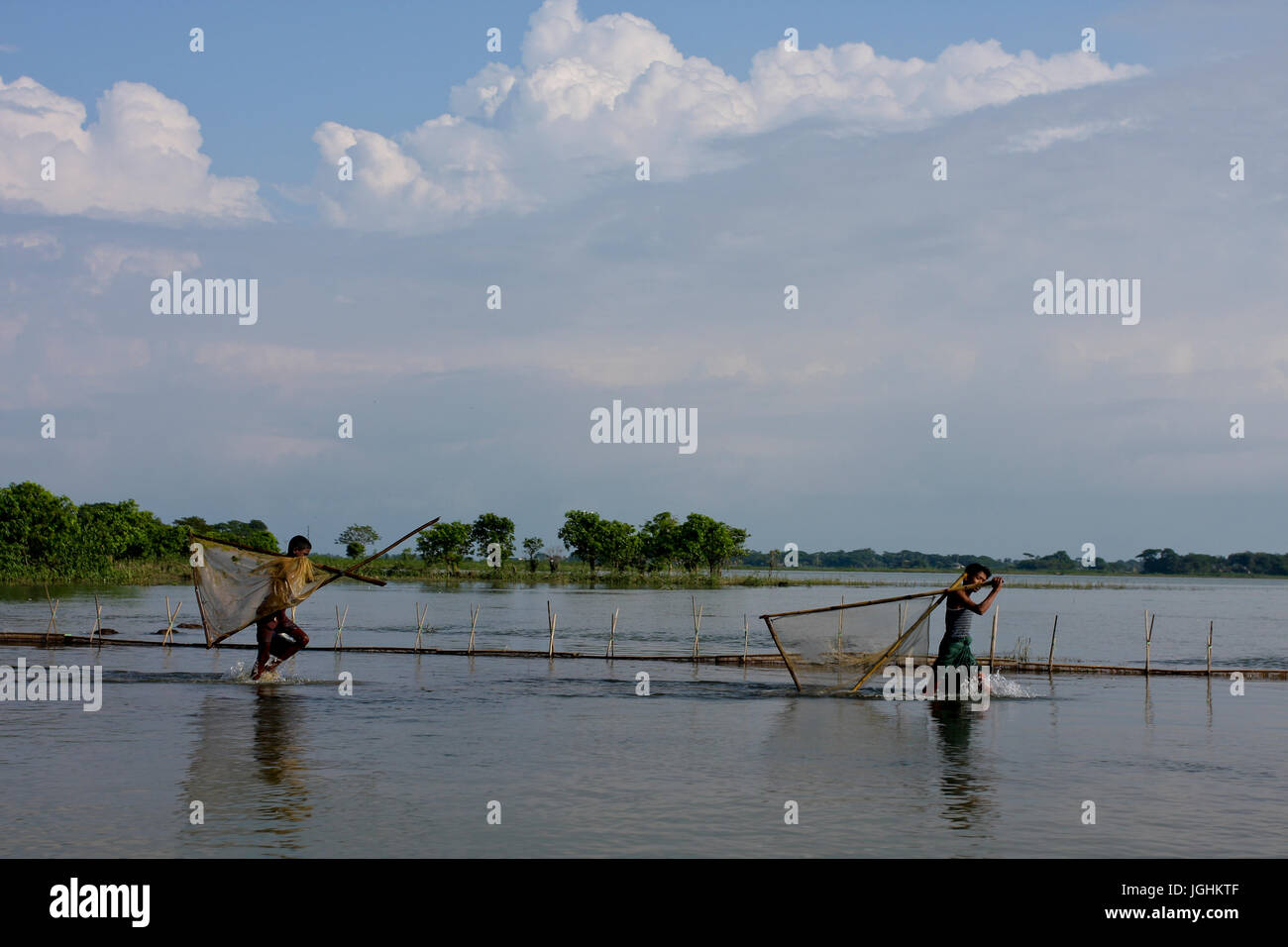 Les pêcheurs de patauger dans l'Dingapota Dingapota Haor ou grand marais dans Mohonganj dans le district de Netrokona. Le Bangladesh. Banque D'Images