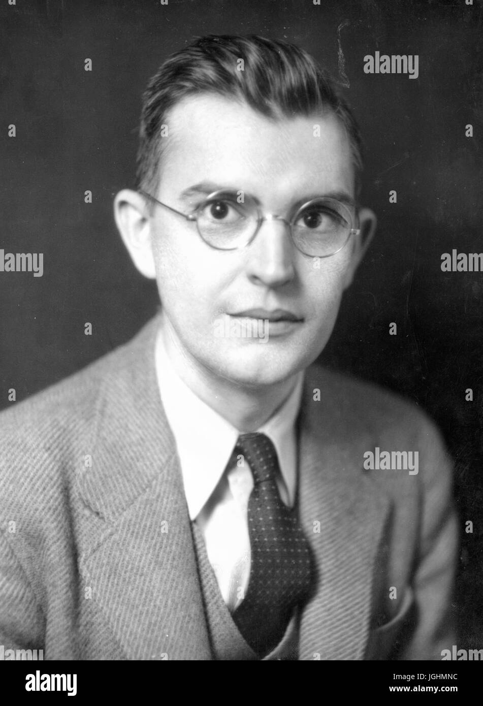 Portrait de George Heberton Evans Junior, l'économiste américain et professeur d'économie politique à l'Université Johns Hopkins (1925-1970, Président 1942-1960 du ministère), assis vêtu d'un costume de tweed et verres, trois quart vue, épaules, autour de 42 ans, Baltimore, Maryland, 1940. Banque D'Images