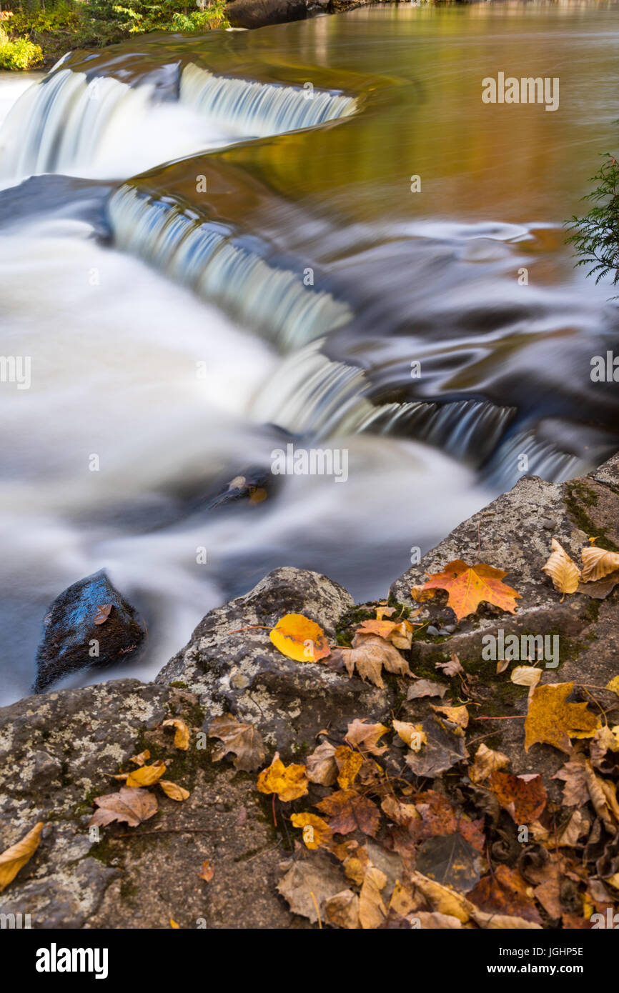 La rivière déborde en Ontongan La Bond tombe dans la Péninsule Supérieure du Michigan. Jeter les feuilles d'automne sur streawn rock aux côtés de l'eau. Banque D'Images