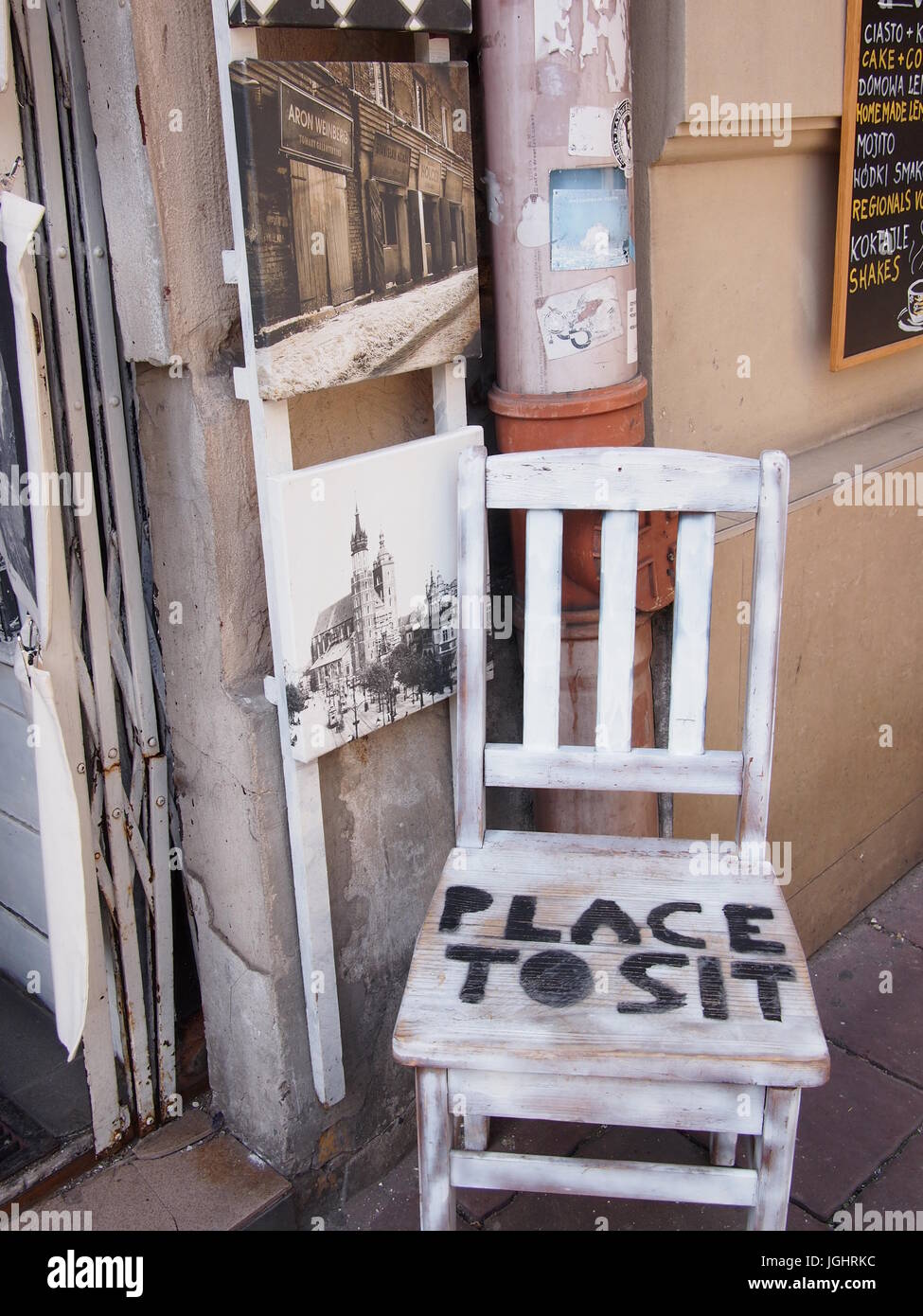 Une seule chaise en bois à l'extérieur d'un café à Cracovie, Pologne, peint avec la phrase 'la place pour s'asseoir" Banque D'Images