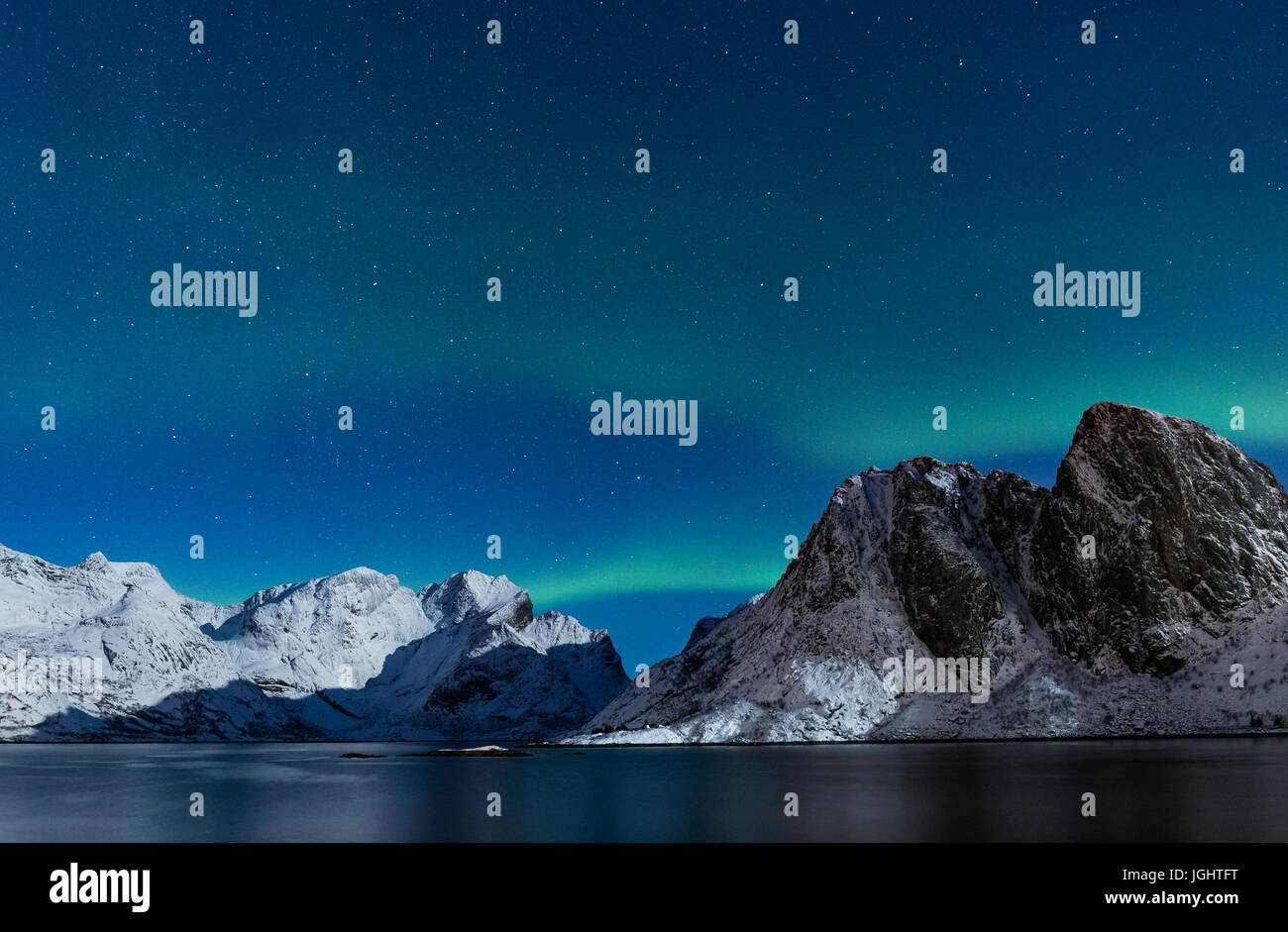Ciel étoilé avec northern lights raide ofer, montagnes rocheuses couvertes de neige dans le nord de la Norvège à l'hiver Banque D'Images