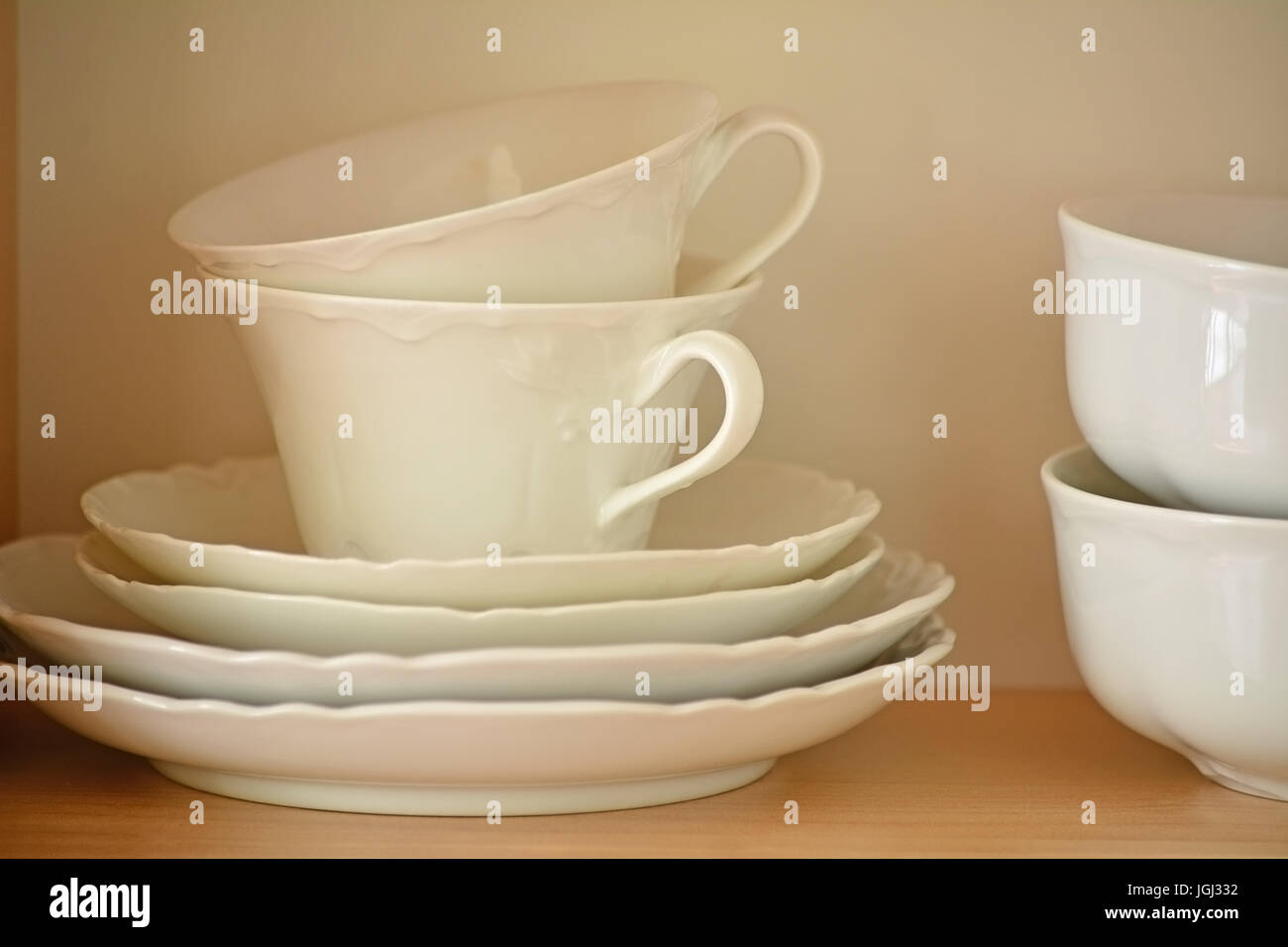 Tasses et soucoupes thé blanc avec bols sur planche en bois. Format horizontal avec focus sélectif. Banque D'Images