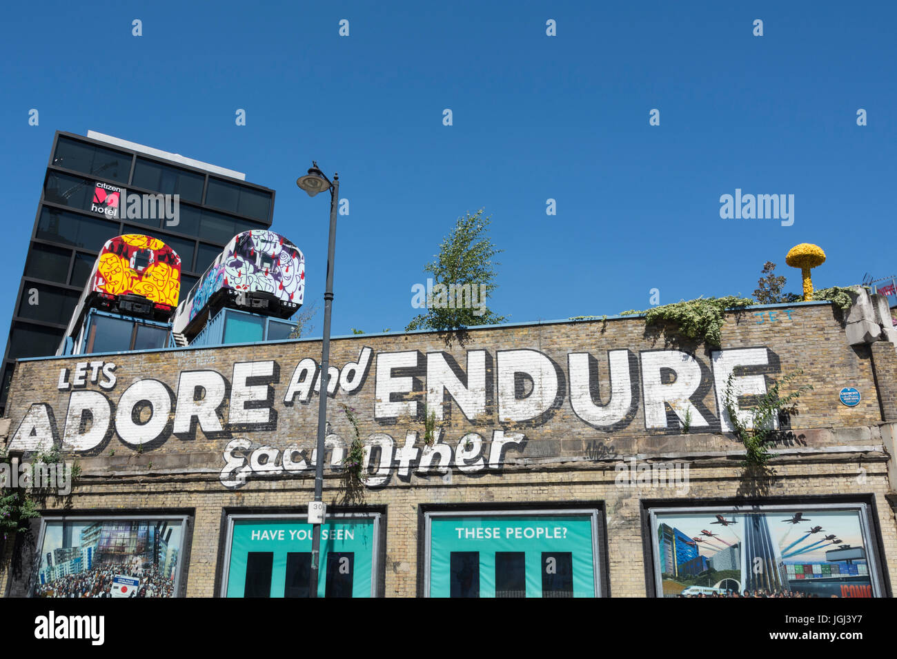 L'adorer et permet de supporter l'autre graffiti par Steven Pouvoirs dans Great Eastern Street, Londres. Banque D'Images