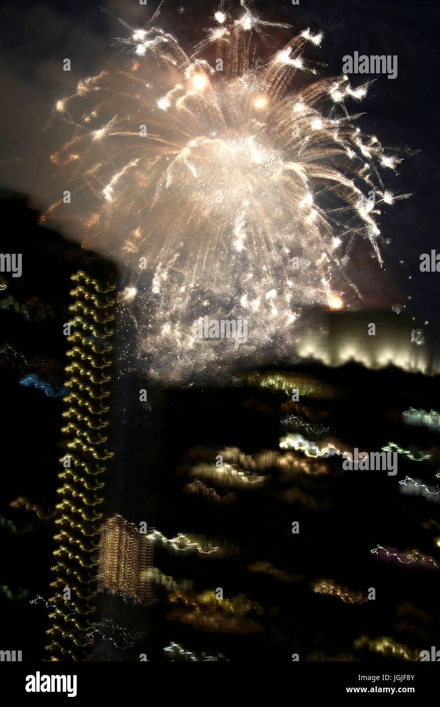 Des traînées et des salves de cierges colorés depuis Fireworks sur NYC skyline Banque D'Images