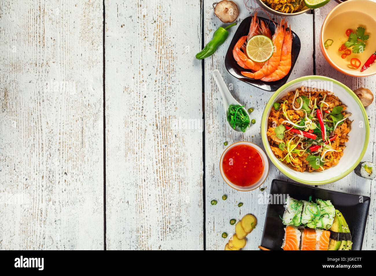 La nourriture asiatique servi sur table en bois blanc, vue du dessus, de l'espace pour le texte. La cuisine vietnamienne et chinoise. Banque D'Images