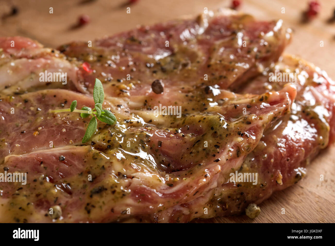 La viande de porc cru mariné prêt à être mis sur le grill avec le poivre et le thym Banque D'Images