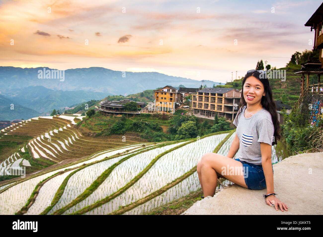 Girl enjoying coucher du soleil à champ de riz en terrasses dans la région de Longji, Guilin, Chine Banque D'Images