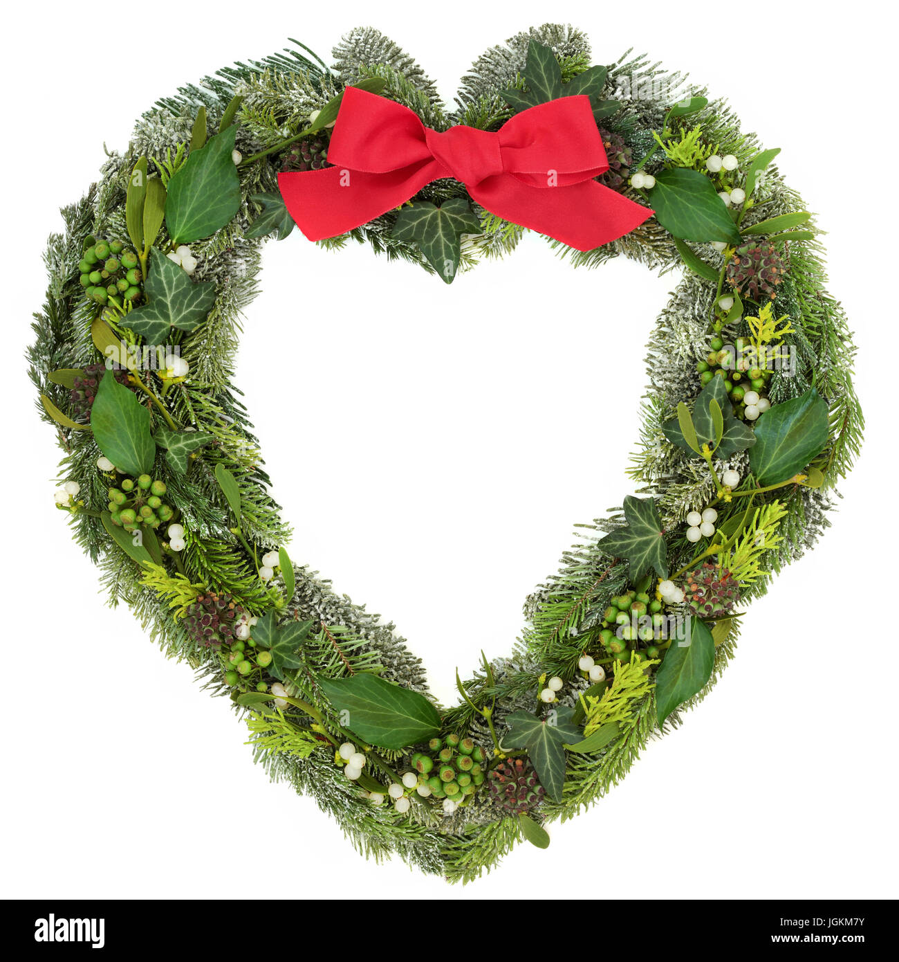 Couronne d'hiver en forme de coeur avec red bow, le gui, l'épinette bleue couverte de neige et sapin juniper sur fond blanc. Banque D'Images Couronne d'hiver en forme de coeur avec red bow, le gui, l'épinette bleue couverte de neige et sapin juniper sur fond blanc. Banque D'Images