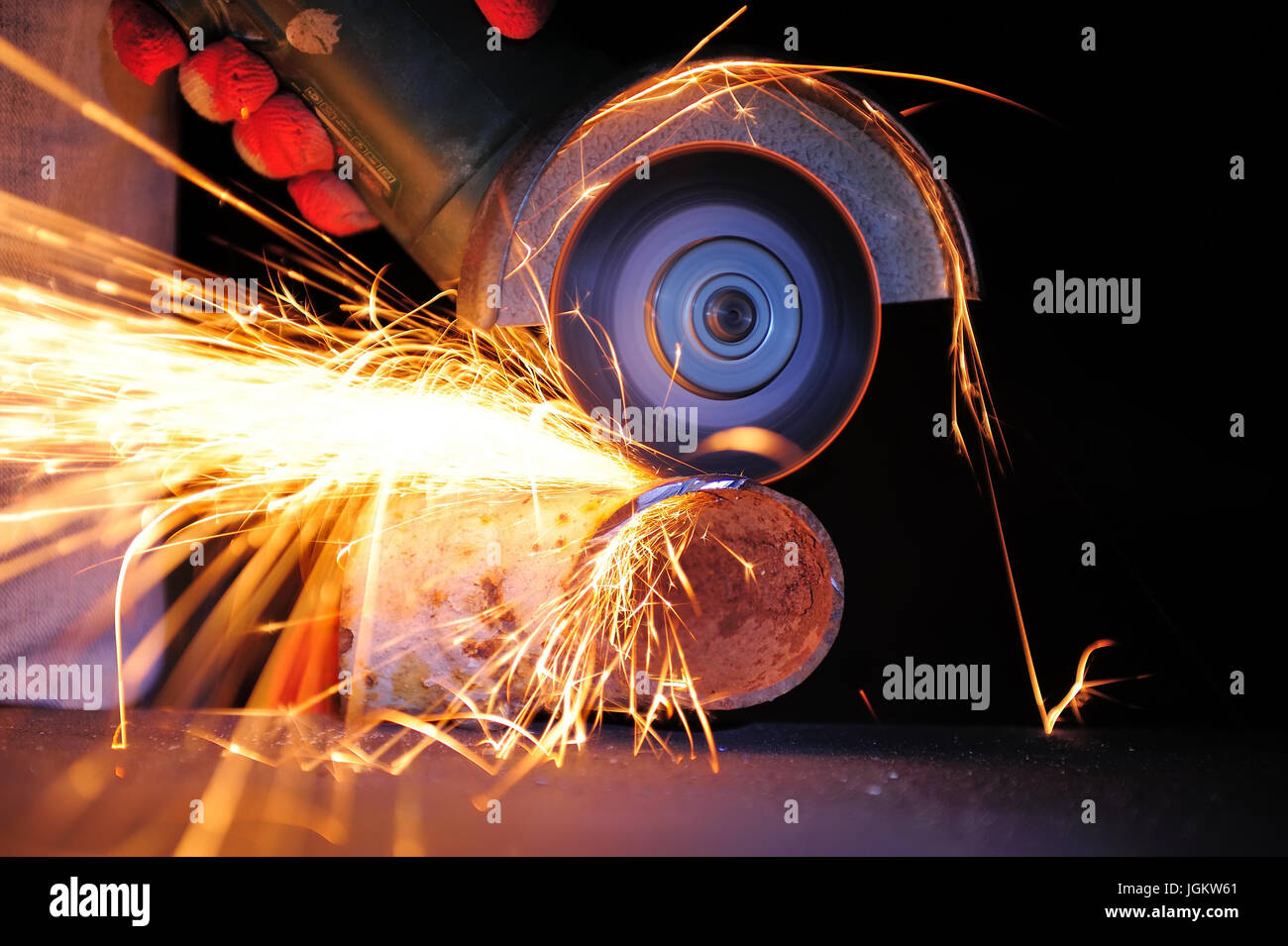 Worker cutting metal avec une meuleuse. Tandis que le broyage de Sparks Banque D'Images