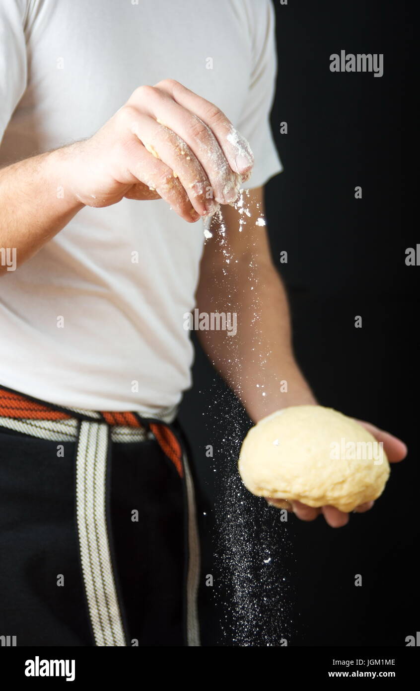 Homme baker holding pâte de farine et de pain tout en Banque D'Images
