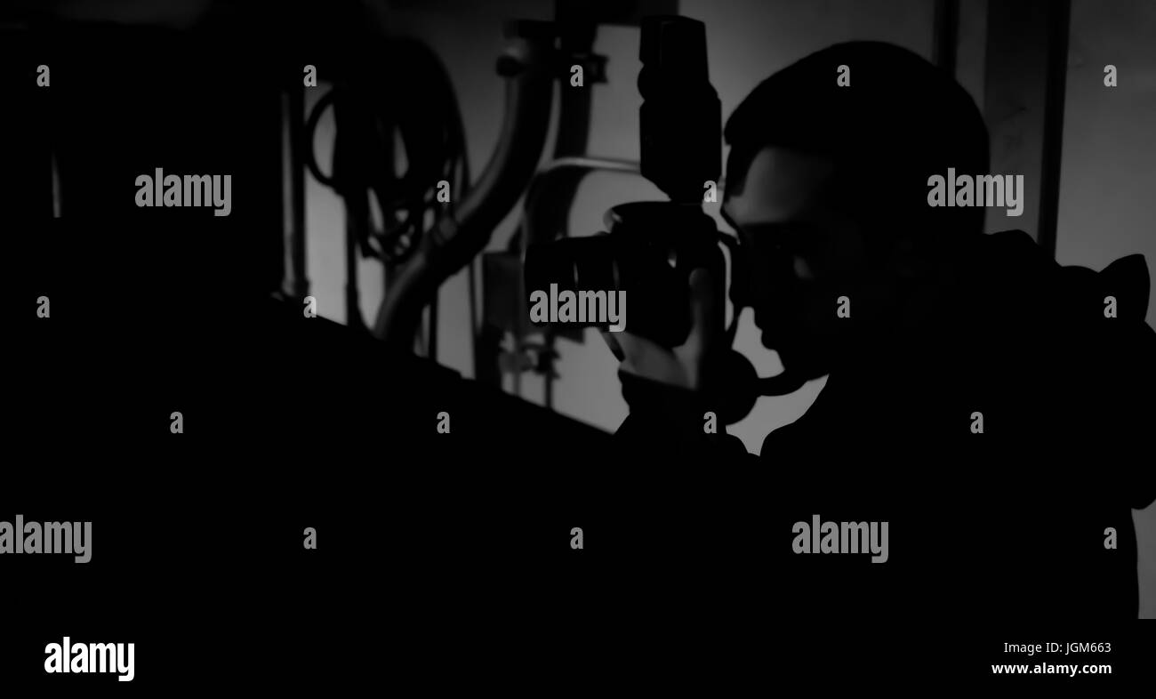 Photographe prenant des photos dans des conditions de faible luminosité Banque D'Images