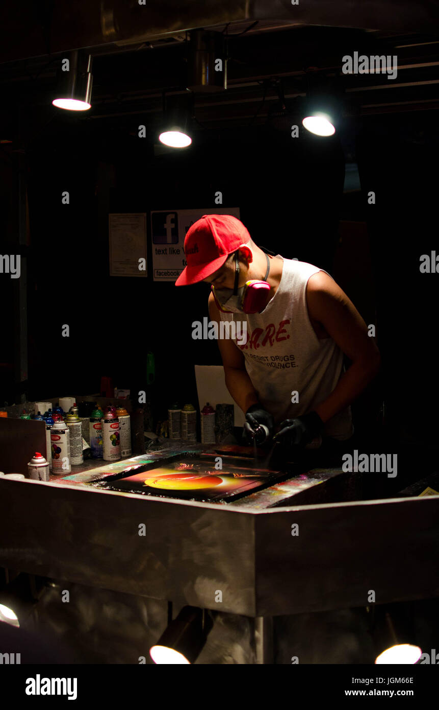 Homme faisant de l'art du graffiti en utilisant une table de spinning Banque D'Images