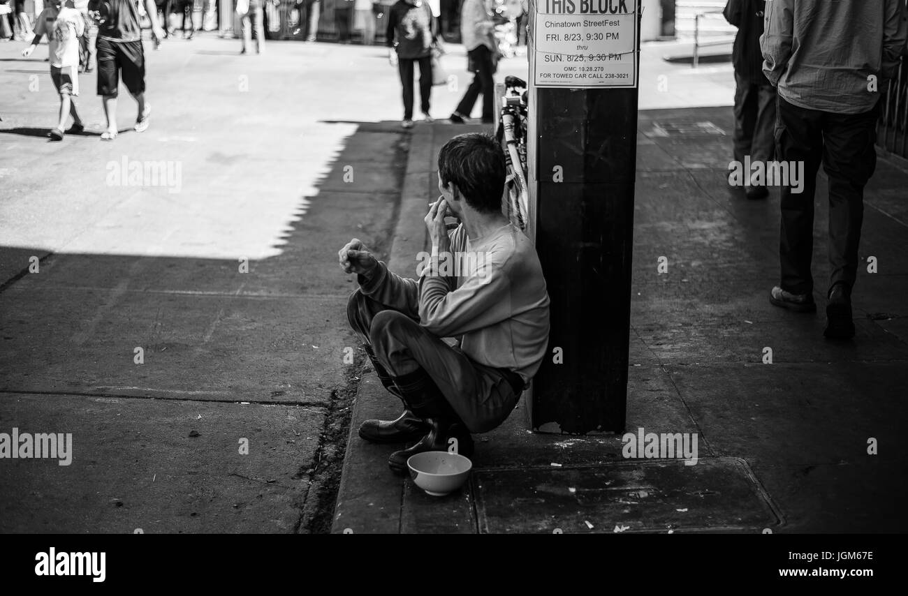 Man smoking a cigarette dans les rues de Chinatown Banque D'Images